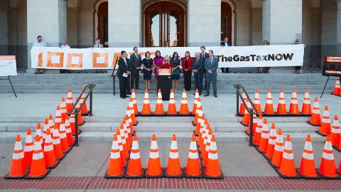 Image caption: Republican lawmakers stand outside the California Capitol behind traffic cones creating the numeral "100."