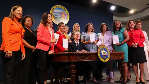 Image caption: In a photo posted on social media, Gov. Gavin Newsom poses with members of the California Legislative Women’s Caucus after signing a series of bills.