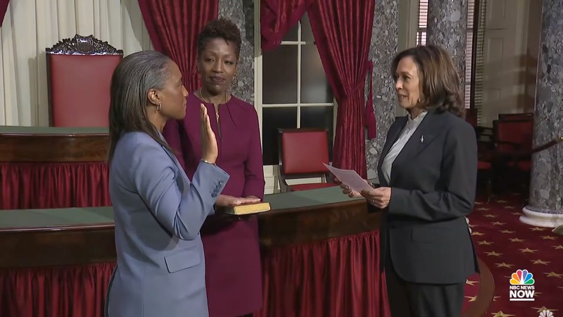 Laphonza Butler—with her hand on a bible being held by her wife, Neneki Lee—is sworn into the US Senate by Vice Pres. Kamala Harris.