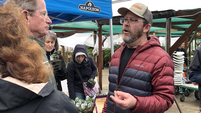 Brad Gates, right, answer questions from gardeners after his tomato presentation at Green Acres' Sacramento store in February 2023. Other attendees look over the tomato plant selection he brought with him.