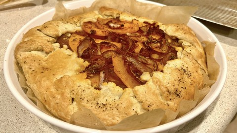 Image caption: Piled with butternut squash slices and red onion, this galette can be made easily with some shortcut ingredients. (Galette was baked on a cookie sheet but moved to a tart pan for easy serving.)