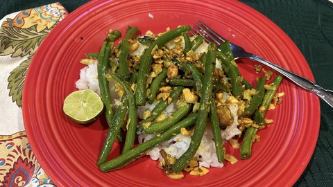 Image caption: Fresh green beans stir-fried with toasted coconut and cashews works as a vegetarian entree or a side dish to a larger meal.