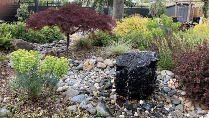 A stone fountain is a focal point in this elegant garden, one of six to be seen on the River Park Garden Tour this Saturday, April 20.
