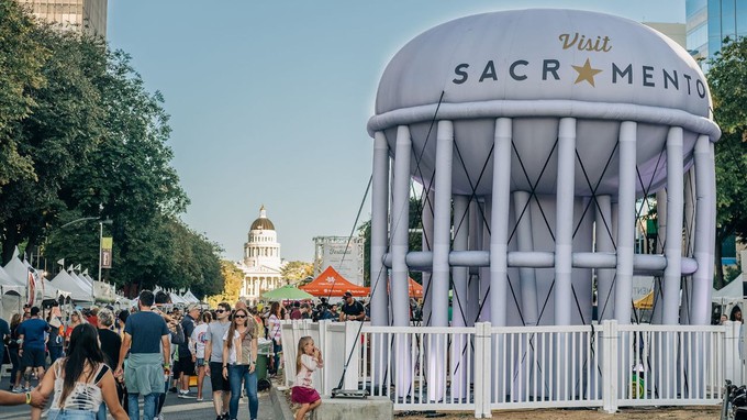 Image caption: People admire the inflatable version of Sacramento's iconic water tower on the Capitol Mall during the Farm-to-Fork Street Festival.