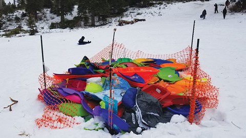 Image caption: A sled corral full of broken plastic sleds at Fallen Leaf Lake Hill.
