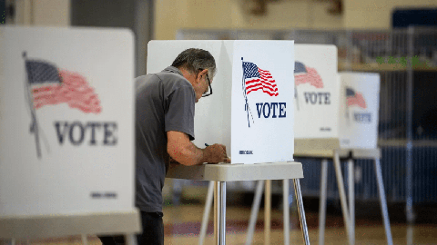 Image caption: A voter fills out their ballot at a voting site at the Hamilton School gymnasium in central Fresno on June 7, 2022.