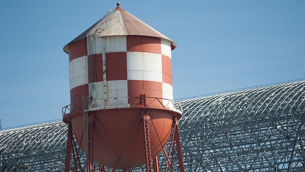 The water tower at Moffett Field in front of Hangar One, one of the world’s largest freestanding structures, is a visual representation of Silicon Valley’s agricultural past and its military-industrial history.