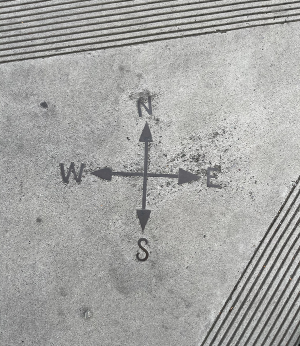 A compass embedded in the sidewalk in front of the Cruzio Building, dating back to when it was the Sentinel Building and home of the Santa Cruz Sentinel.