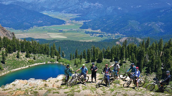 A group of cyclists seen rest on a ridge in Plumas National Forest.