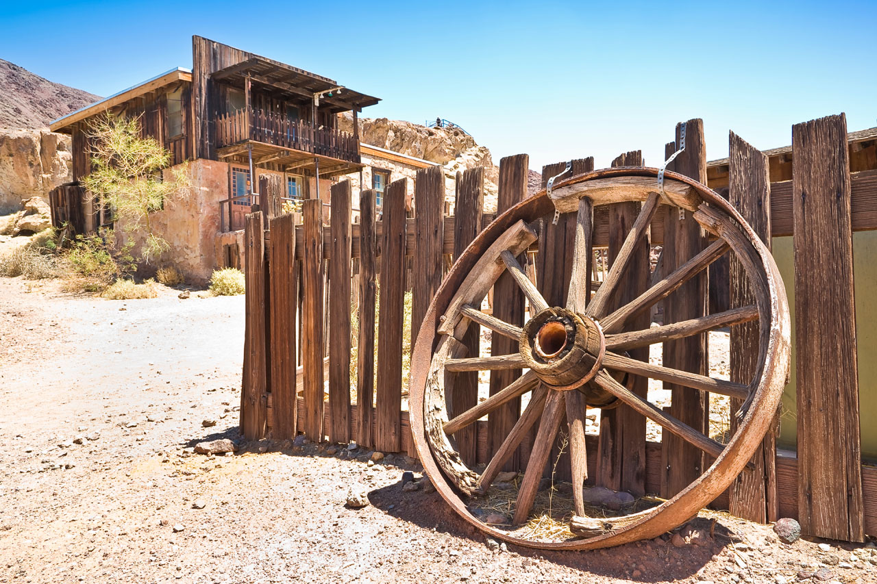 Weathered building, fence and wagon wheel in Calico ghost town