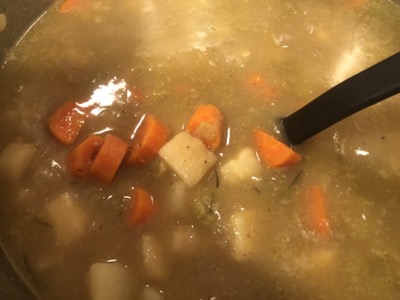 Closeup of carrot and potato chunks in broth