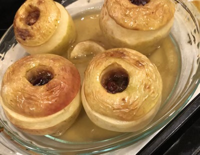 4 baked apples, fresh out of the oven, in a glass pie plate
