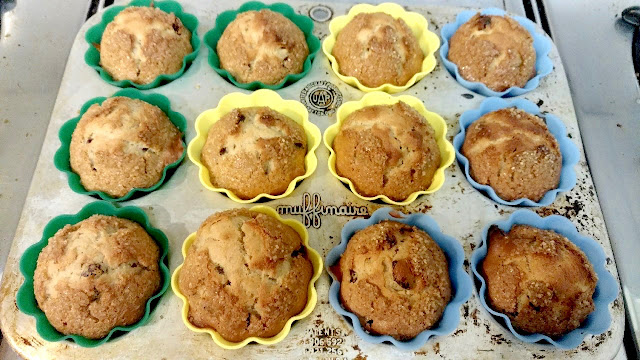 Muffin pan with muffins in green, yellow, blue cups