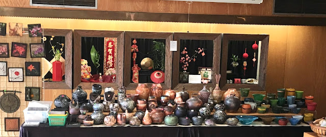 Large table filled with handmade pots