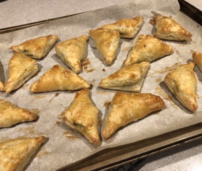 A pan full of baked turnovers, cooling on a rack