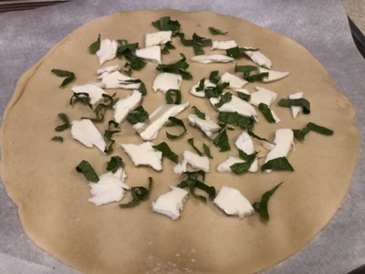 Basil and cheese on a pastry round