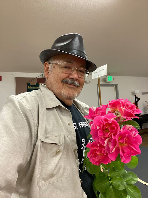 Baldo Villegas holding pink roses