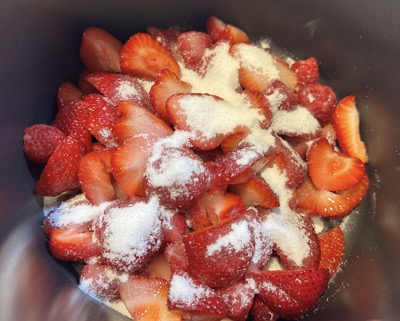 Cut-up strawberries with sugar in a pot