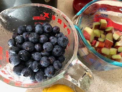 Measuring cups with blueberries and chopped rhubarb