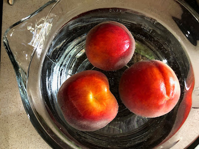 Peaches in a bowl of water