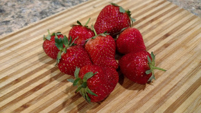 Pile of fresh strawberries on a cutting board