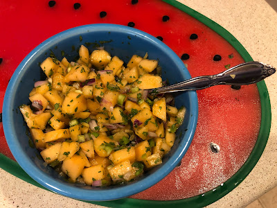 Blue bowl of salsa on a red cutting mat