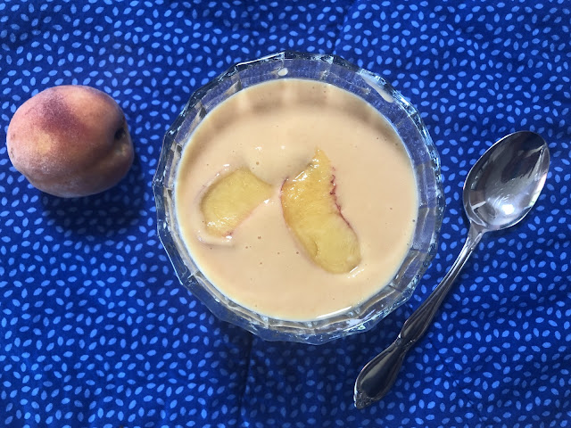 Peach soup in a dish on a blue placemat