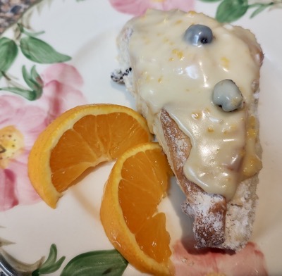 A glazed orange scone on a plate