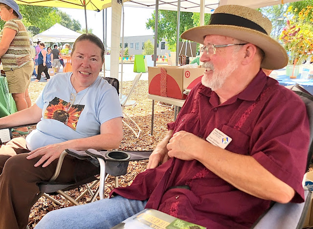 Woman in blue shirt, man in red shirt and straw hat