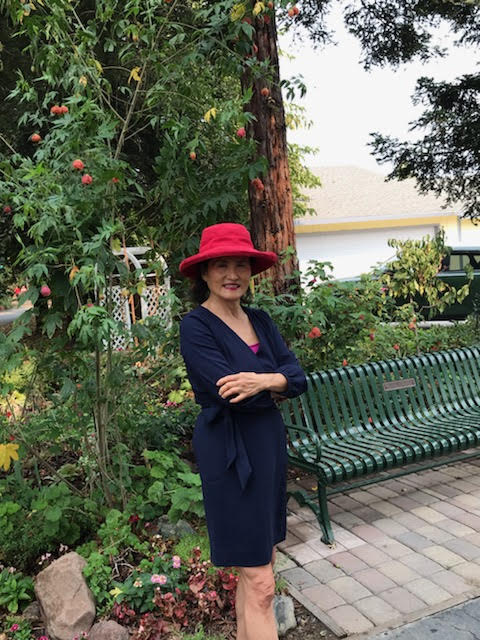 Woman in red hat next to green bench