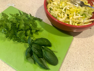 Parsley and basil leaves on green cutting board