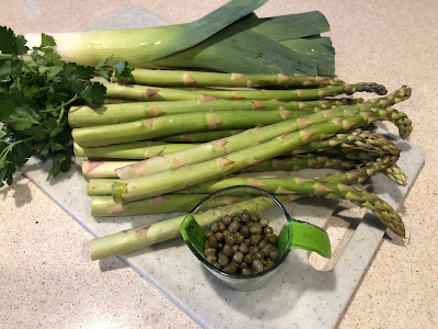Asparagus stalks, a leek, some parsley and a small cup of capers