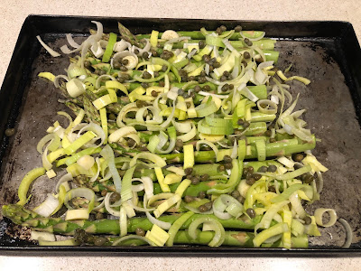 Asparagus, leeks and capers on baking pan