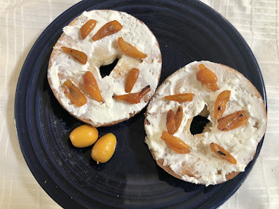Bagel with cream cheese and kumquat pieces