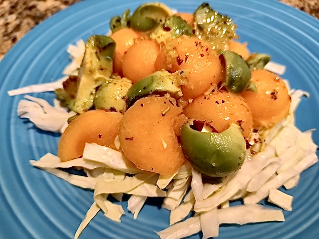 Blue plate with melon balls and avocado