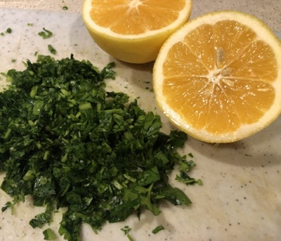 Two lemon halves and a pile of chopped parsley