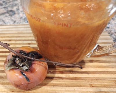 One persimmons and a measuring cup of pulp