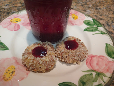 2 cookies on a plate with a jelly jar