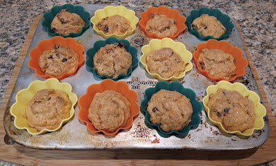 Muffin batter in orange, blue and yellow liners