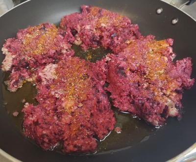 Dark red hash patties in a pan