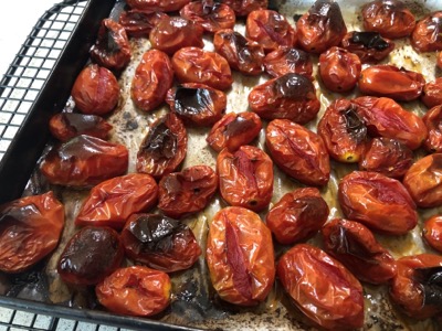 Roasted red tomatoes on a pan