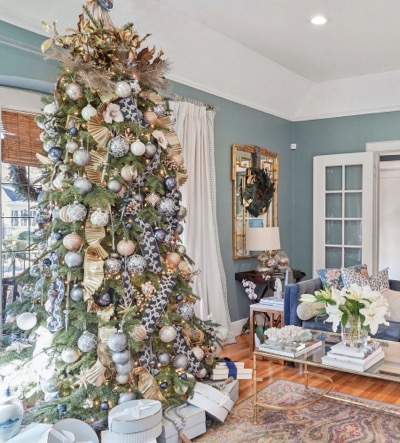 Blue and white sitting room with a tall Christmas tree at left