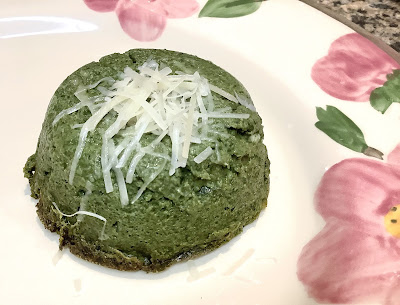 Cheese-topped spinach timbale on a plate