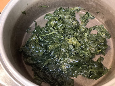 Cooked spinach in a metal pan