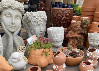 Various ceramic and terra cotta plant containers on a table