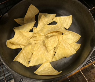 Triangles of tortillas in a cast iron skillet