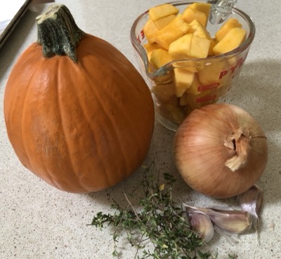 Pumpkin chunks, a small pumpkin, an onion, 3 garlic cloves and a bunch of thyme