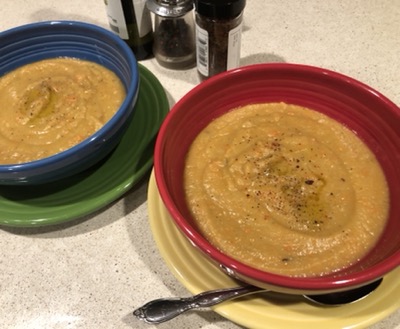 one red and one blue bowl of soup on a counter