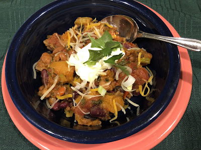 Chili in blue bowl with garnishes