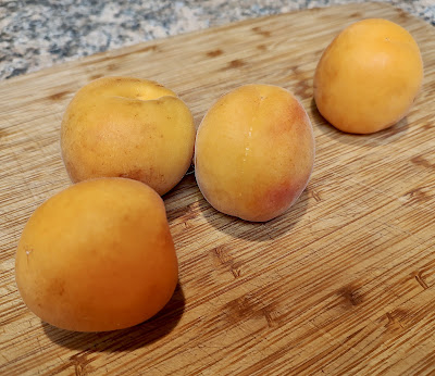 4 apricots on a wooden board